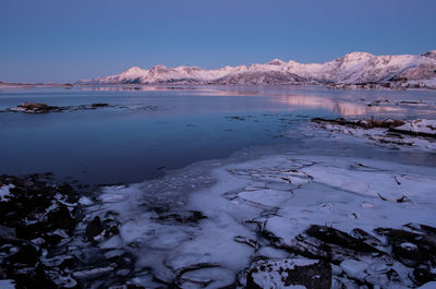 Scenic view of lake and mountains against clear sky