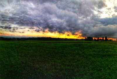 Scenic view of field against dramatic sky