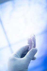 Close-up of hand holding dentures at clinic