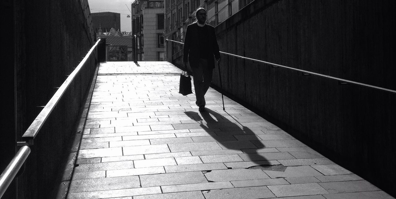 architecture, built structure, the way forward, building exterior, walking, rear view, men, full length, shadow, cobblestone, railing, walkway, paving stone, sunlight, lifestyles, sidewalk, unrecognizable person, street