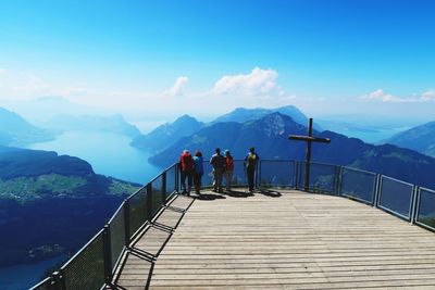 Rear view of people on mountain against sky