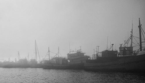 Boats in sea against clear sky