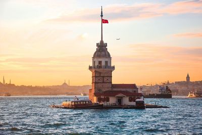 Ship in sea against sky during sunset