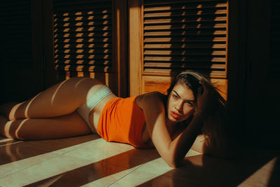 Portrait of woman lying down on floor at home