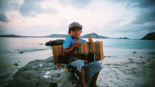 Portrait of boy on beach against sky