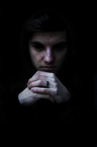 Close-up of sad man against black background