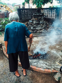 Rear view of man standing against fire