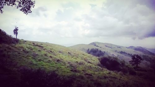 Scenic view of mountains against cloudy sky