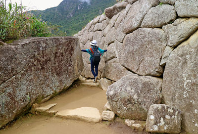 Full length of man on rocks against mountains