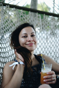 Portrait of a smiling young woman drinking glass