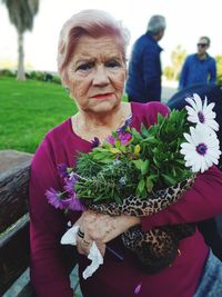 Portrait of woman holding flowers bouquet during event