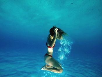 Side view of young woman swimming undersea
