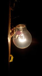 Close-up of lit lamp in dark room