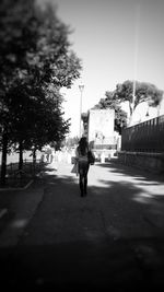 Rear view of man walking on footpath