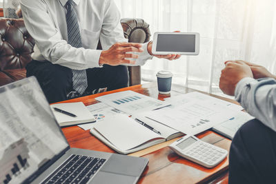 Midsection of man using laptop on table