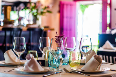 Wineglasses with plates and napkins arranged on table