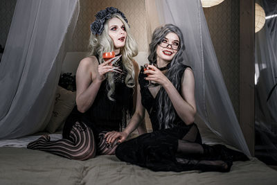 Young woman sitting on bed in bedroom