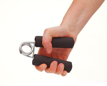 Close-up of hand holding camera over white background