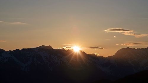 Scenic view of snowcapped mountains against sky during sunset