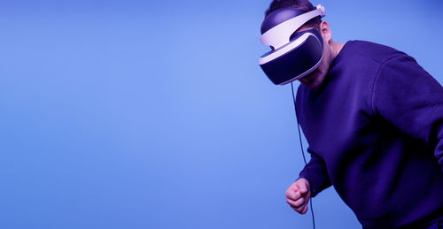 Low angle view of man standing against blue sky