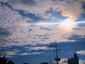 Low angle view of silhouette telephone pole against sky