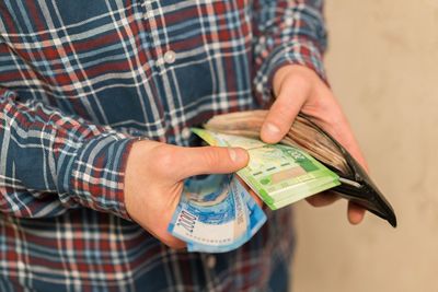 Midsection of man removing paper currencies from wallet