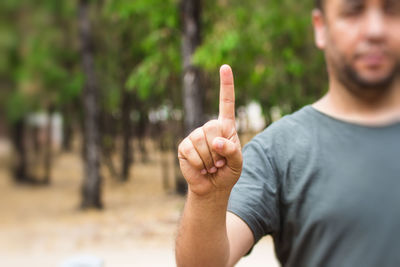 Midsection of man gesturing in park