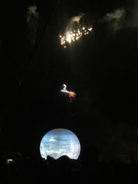 Low angle view of illuminated lights against sky at night