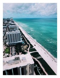 High angle view of cityscape by sea against sky