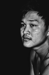 Close-up of young man against black background