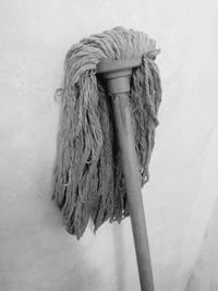 Close-up of rope tied on wooden post against wall