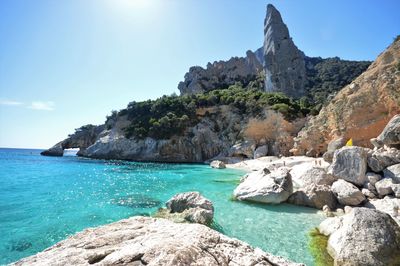 Rock formations by sea against sky