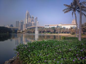 View of fountain in city against clear blue sky