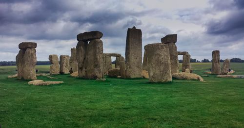 Built structure on field against cloudy sky