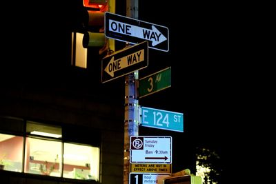 Low angle view of road sign at night