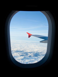 View of cloudy sky seen through airplane window