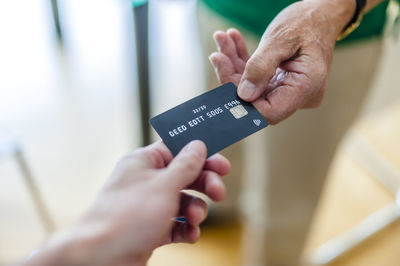 Close-up of two hands with credit card