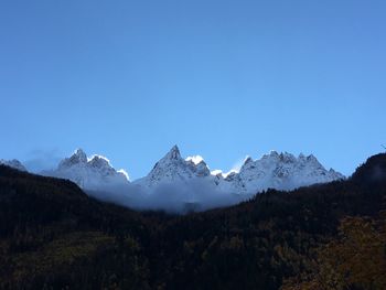 Scenic view of snowcapped mountains against clear blue sky