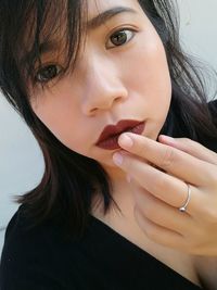 Close-up portrait of young woman wearing lipstick at home