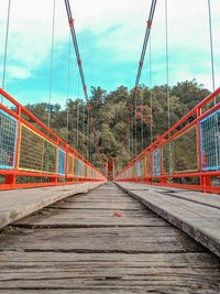 Empty footbridge against sky