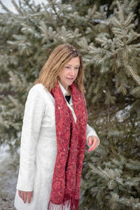 Portrait of young woman standing in snow