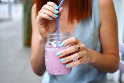 Midsection of woman holding drink