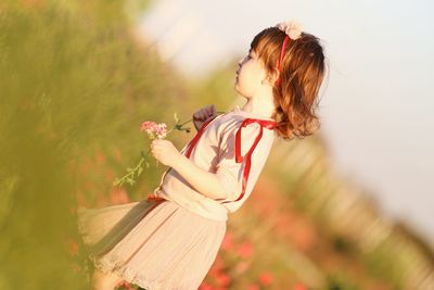 Side view of woman holding plant