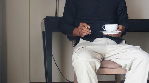 Activity at home of people drinking a cup of coffee or tea while smoking a cigarette.