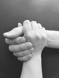 Close-up of father holding baby hand