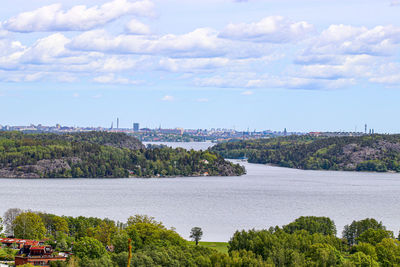 Scenic view of river by trees against sky