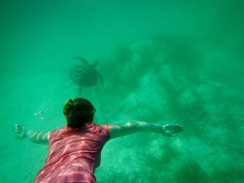 Rear view of woman snorkeling undersea