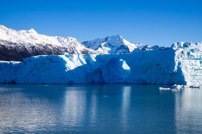 Scenic view of snowcapped mountains against blue sky