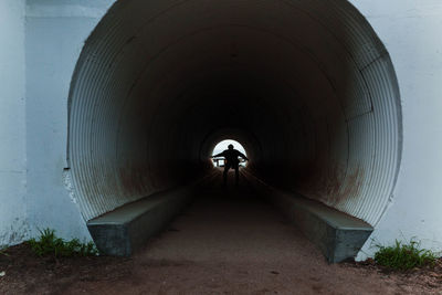 Rear view of man standing in tunnel