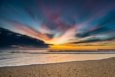 Scenic view of beach against sky during sunset